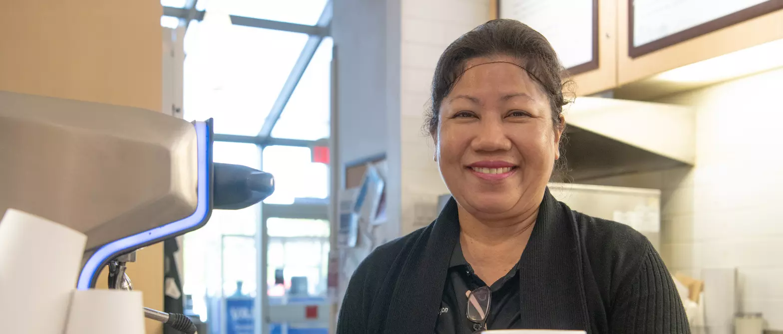 A barista hands the viewer a coffee at the cafe in BC Children's Hospital