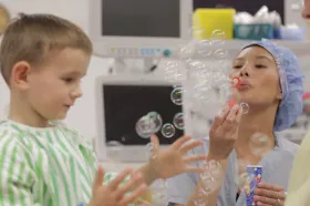Nurse blowing bubbles with patient