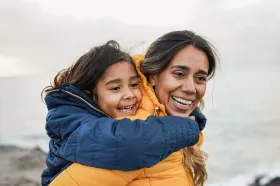 A parent and child laughing while on a hike