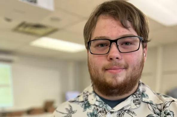 A patient holds up a graduation certificate